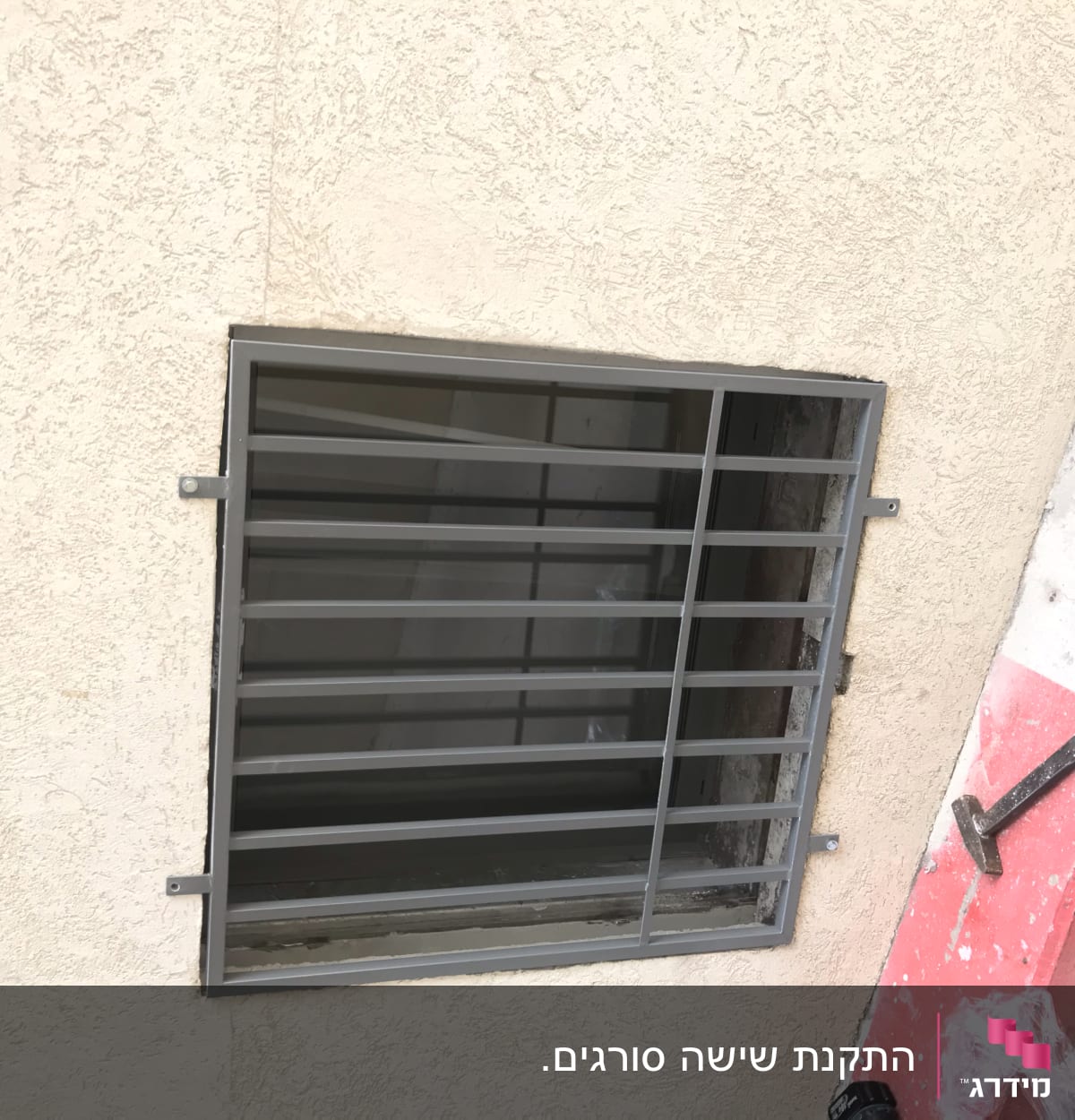 סורג מתכת מותקן על חלון בקיר חיצוני